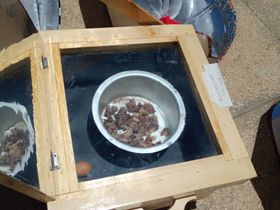 Box solar cooker frying meat